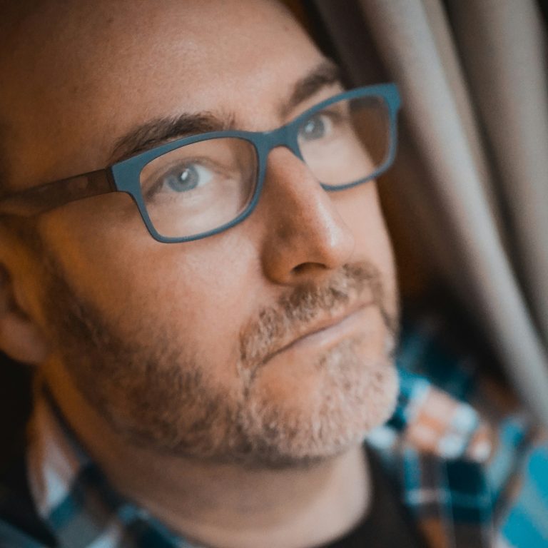 Person wearing glasses in a focused close-up portrait